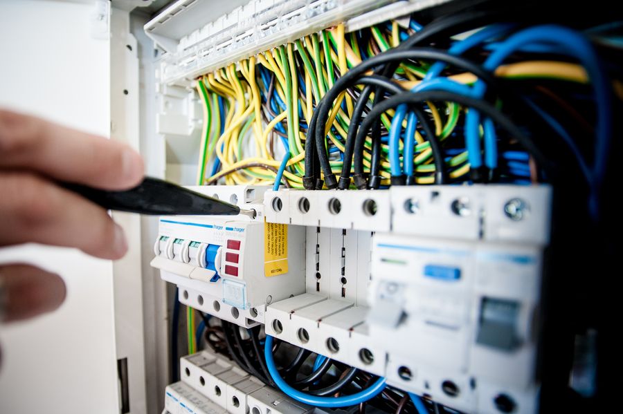 Electrician working on an open electrical circuit panel